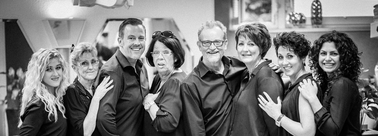 Das Team von Friseur Schilling, acht Personen in schwarzen Hemden, lachend im Salon